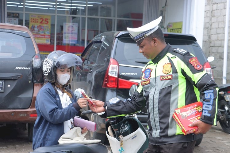 Unik, Anggota Polres TTS Bagi  Makanan Beng-beng  Sambil  Imbau Kamseltibcarlantas